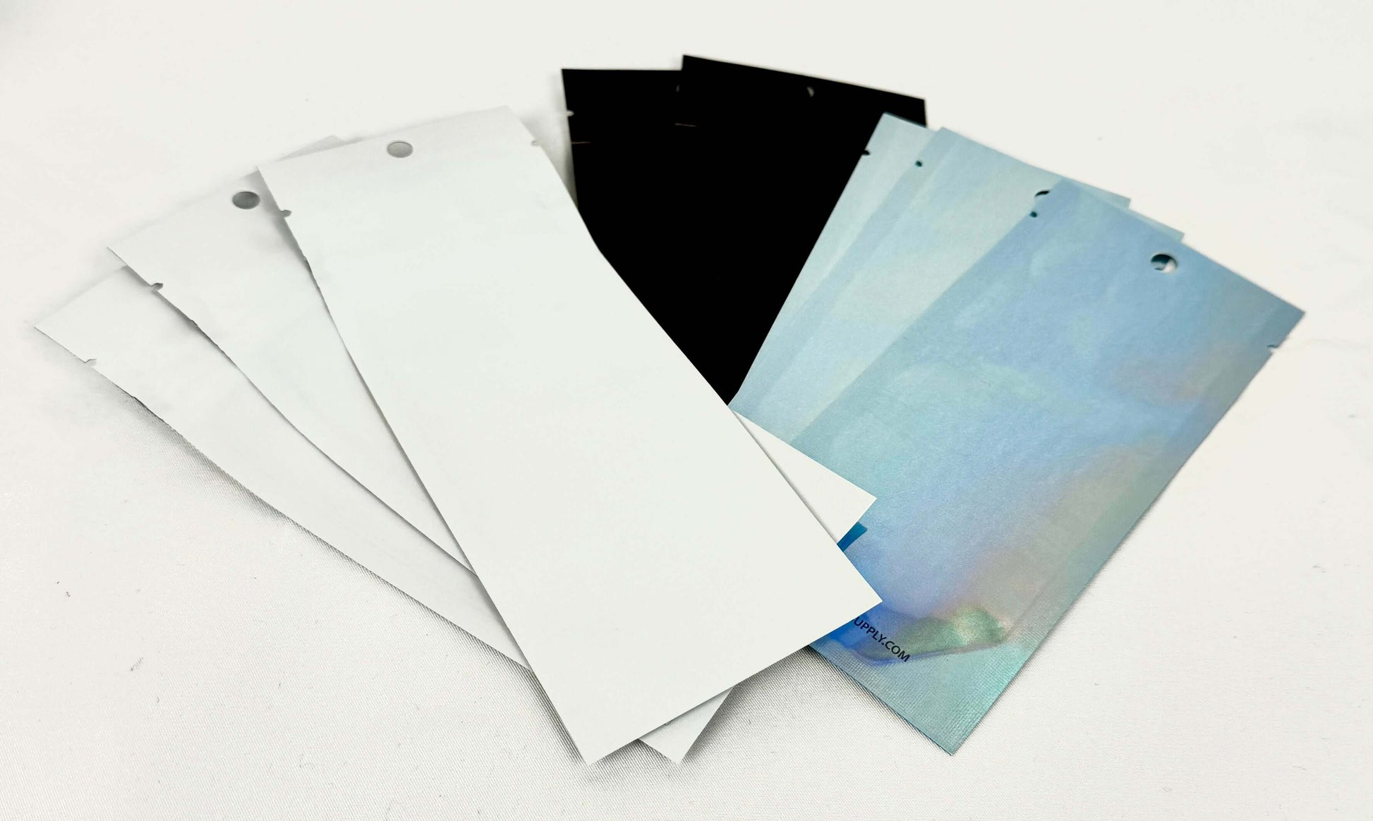 Vape Mylar Bags in black, white, and holographic colors stacked together on a white surface.