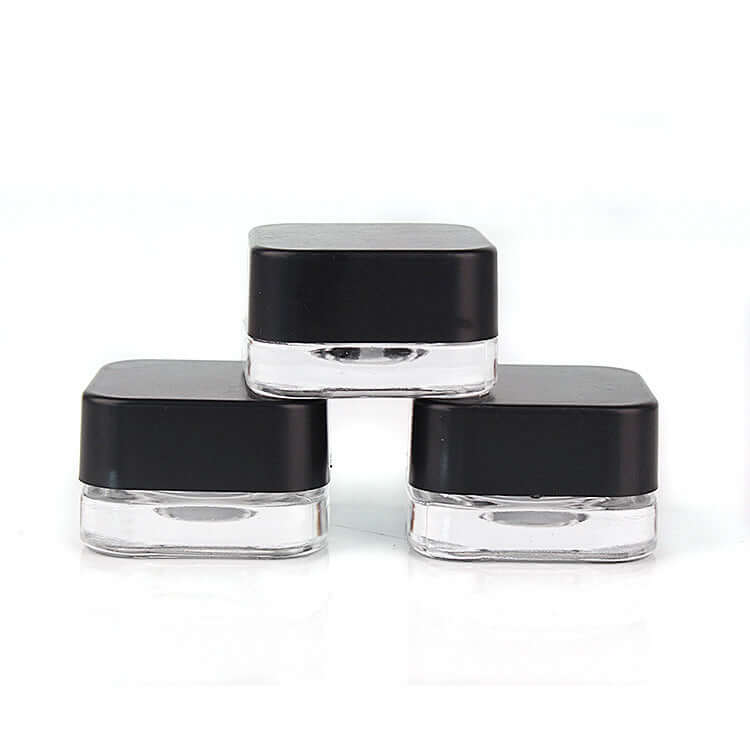 Three 5 ML square clear glass jars with black lids, ideal for cosmetics and sample packaging.