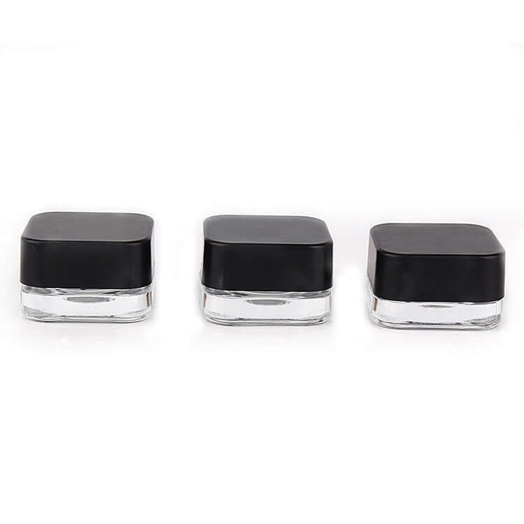 Set of three 5 ML square clear glass jars with black lids for skincare and sample packaging.