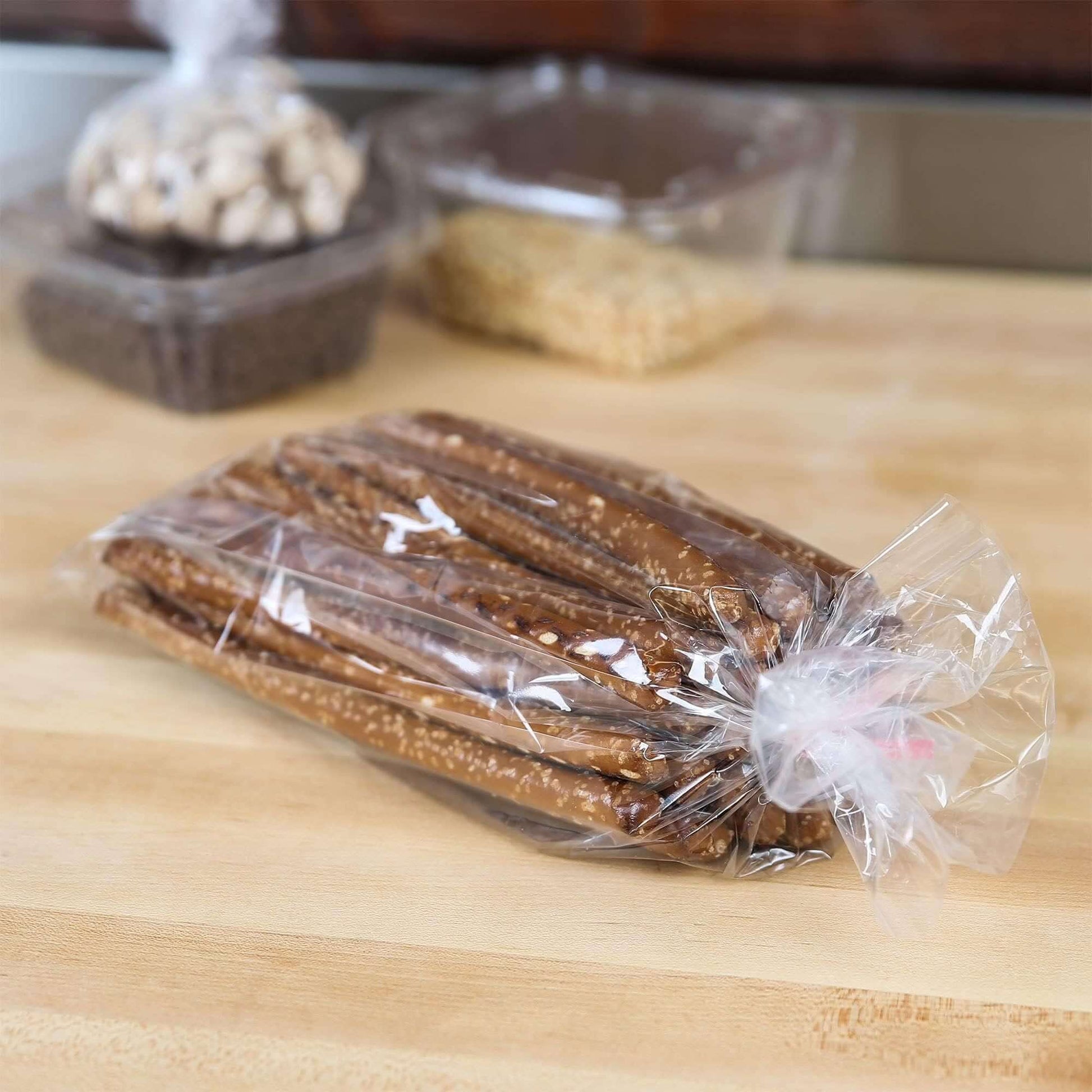 Clear gusseted plastic bag holding pretzel sticks on a wooden surface, perfect for showcasing baked treats.