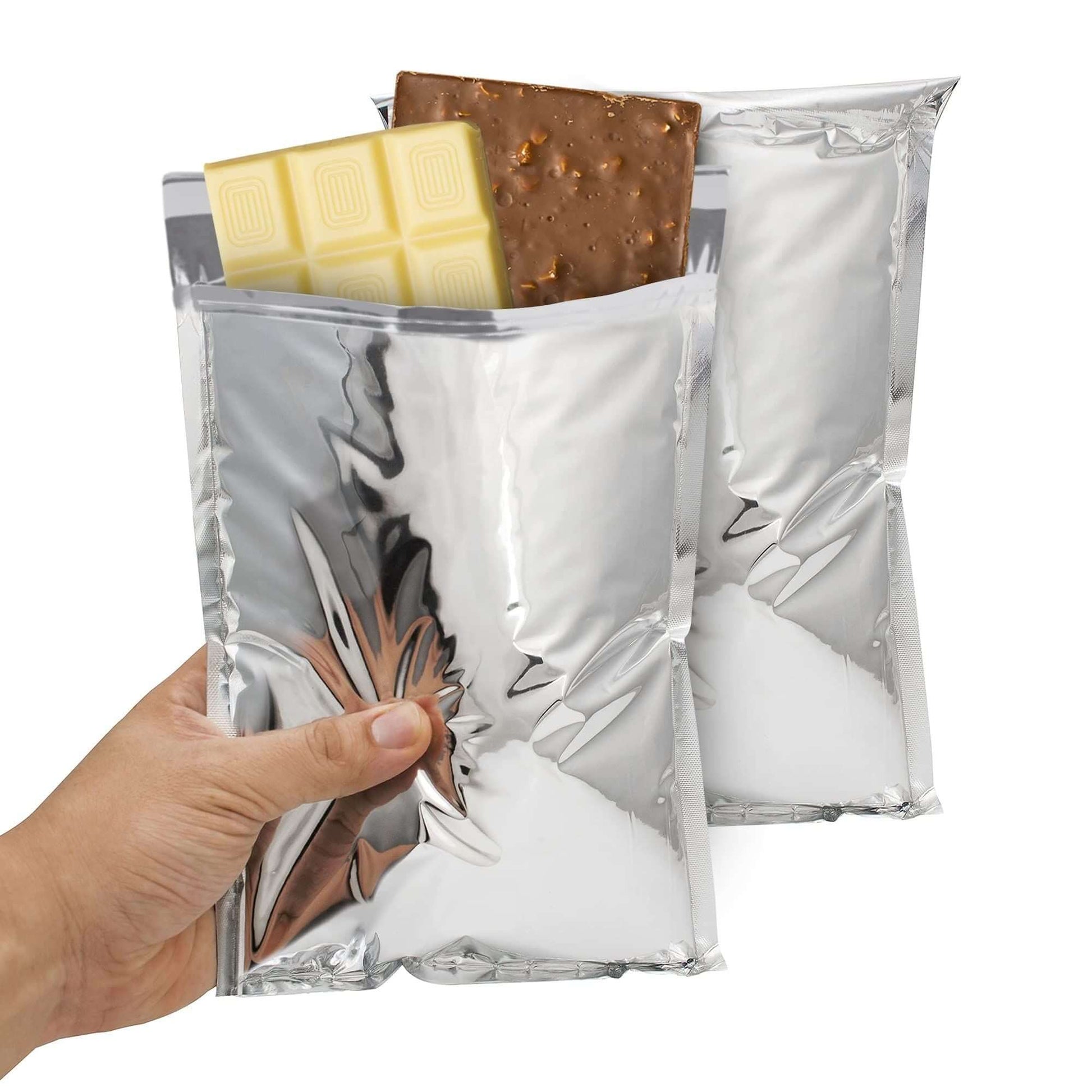 Person holding two insulated aluminum mailers with candy bars inside, ideal for shipping food.