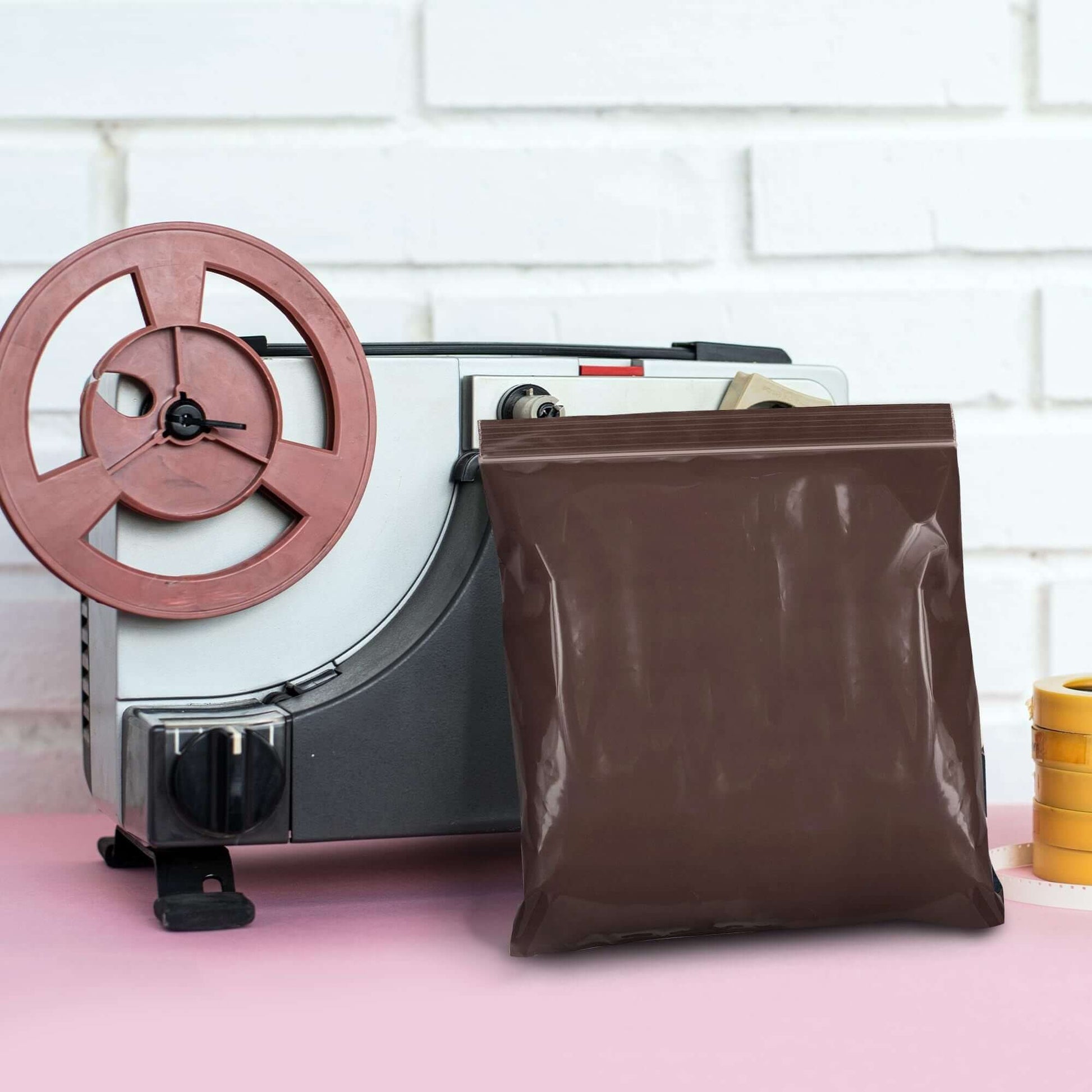 Brown plastic zip bag on a table beside a vintage tape recorder, showcasing modern packaging solutions.